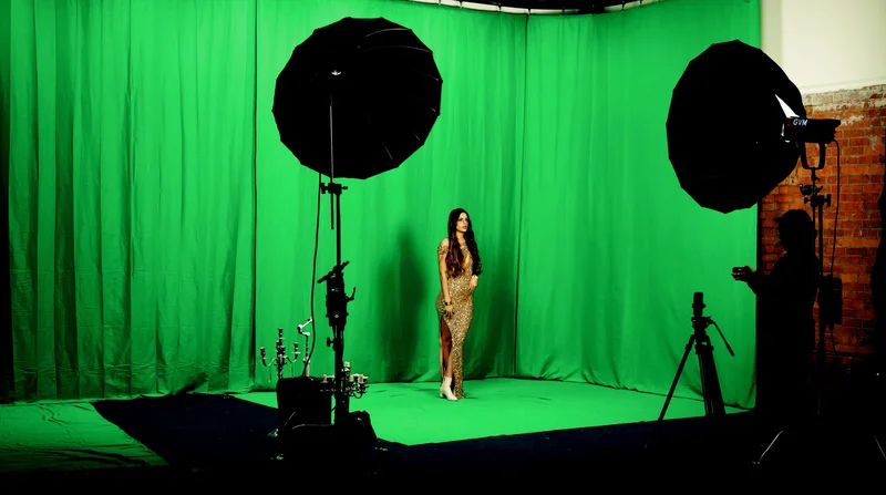 a woman stands in a green screen